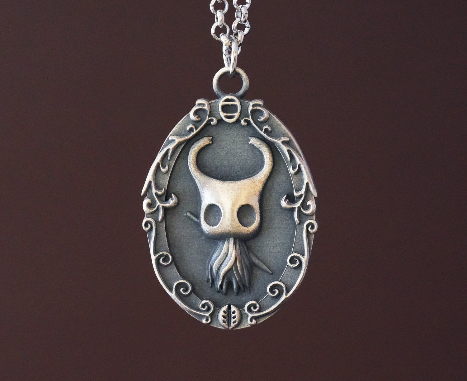 Silver necklace with Hollow Knight pendant, featuring a detailed chain